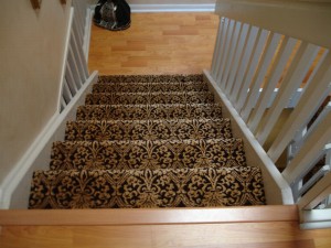 Staircase with ornate patterned carpet runner and wooden steps.