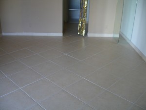 Clean beige tiled floor with a partially open door.