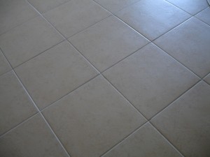 Close-up of beige ceramic floor tiles with grout lines.