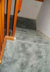Staircase covered entirely with carpet.
