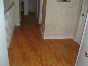 Hallway with wood-look laminate flooring and beige walls.