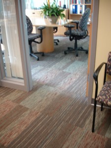 Office hallway with carpet tiles leading to a conference room.