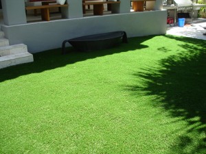 A neatly maintained artificial grass lawn in a backyard.