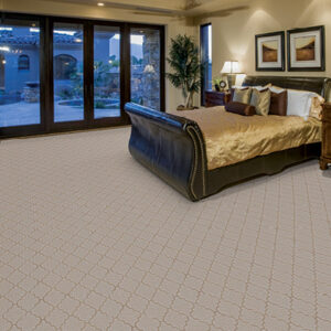 Master bedroom with patterned carpet and patio