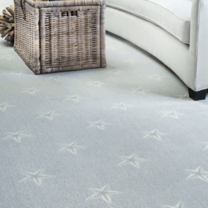 A cozy room with a star-patterned carpet and a wicker basket next to a white sofa.